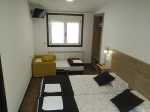 a room with two beds and a couch and a window at Hostel Boente in Boente