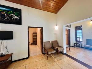 a living room with two chairs and a television at Lovely Home in Panadura