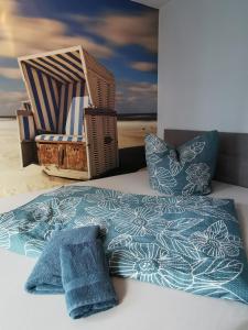 a bed with a blue blanket and a chair at ruhige 3-Raum-Wohnung "BODDENBLICK" mit Balkon und Terrasse in Zingst