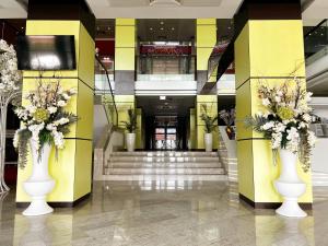 a lobby with two white vases with flowers in them at Caprioara Spa&Wellness Resort in Covasna