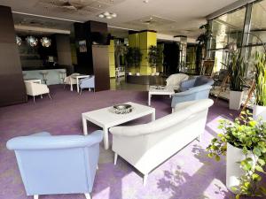 a lobby with white chairs and tables in a building at Caprioara Spa&Wellness Resort in Covasna +111 photos