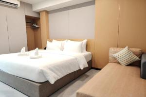 a bedroom with a large white bed and a couch at VELIN Pattaya Hotel-Central Pattaya-3 in Pattaya