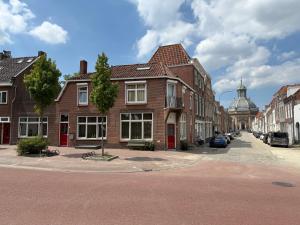 a street with brick houses and a building with a dom at Fortuna Suites in Middelburg +66 photos