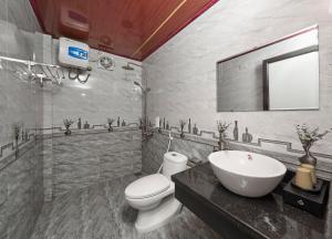 a bathroom with a white toilet and a sink at Tam Coc Green Fields Homestay in Ninh Binh