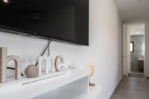 a living room with a tv on a white wall at Serena By Marenssa in Moncarapacho