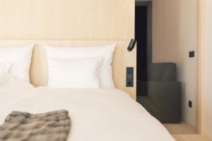 a bedroom with a white bed with white pillows at Farmhouse Milla Montis in Maranza