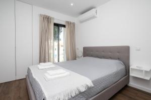 a bedroom with a bed with two towels on it at Serena By Marenssa in Moncarapacho