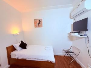 a small bedroom with a bed and a flat screen tv at Coonalpyn Hotel in Coonalpyn