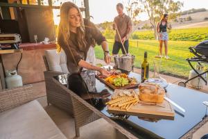 a woman preparing food on a picnic table with a table at Norm's Vineyard Retreat in Lyndoch +43 photos