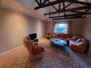 a living room with two couches and a tv at Haus Sonnengarten in Brokstedt