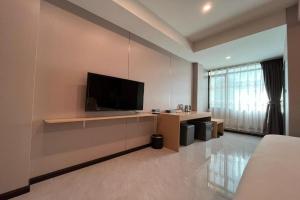 a living room with a flat screen tv on a wall at VELIN Pattaya Hotel-Central Pattaya-2 in Pattaya