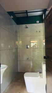 a bathroom with a toilet and a sink at The Western Inn in Mananthavady +26 photos