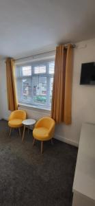 two chairs and a table in a room with a window at Miners Arms in Workington