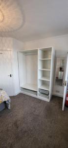 an empty room with white shelves and a bed at Miners Arms in Workington