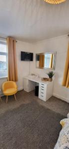a bedroom with a desk and a mirror and a chair at Miners Arms in Workington
