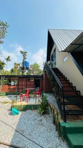 a building with two red chairs and a playground at The Western Inn in Mananthavady
