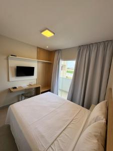 ein Schlafzimmer mit Bett, Schreibtisch und Fernseher in der Unterkunft Hotel Sierra in Cuité