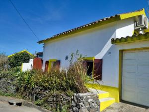 a white and yellow house with a garage at Sunset Nest in Ponta Delgada