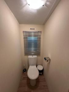 a small bathroom with a toilet and a window at Serenity Beach Pinar in Chipiona +9 photos
