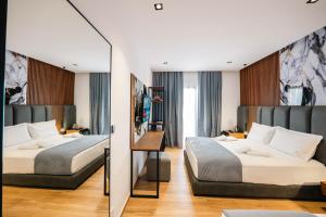 a hotel room with two beds and a mirror at Hotel Siars in Ksamil