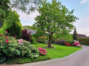 a garden with flowers and a tree in the middle at Haus Sonnengarten in Brokstedt