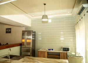 a kitchen with a stainless steel refrigerator and a counter at Résidences Amana in Porto-Novo