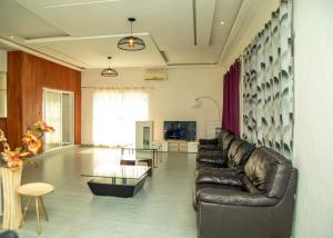 a living room with a leather couch and a table at Résidences Amana in Porto-Novo