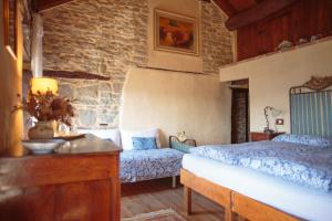 a bedroom with two beds and a stone wall at Ca' d'Alfieri in Bardi