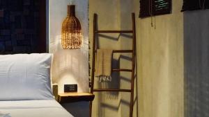 a bedroom with a bed and a hanging lamp at Cala Tuason Villas in General Luna