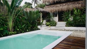 a swimming pool in front of a house with plants at Cala Tuason Villas in General Luna