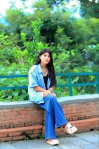 a woman is sitting on a brick wall at Bagchandi resort in Kathmandu