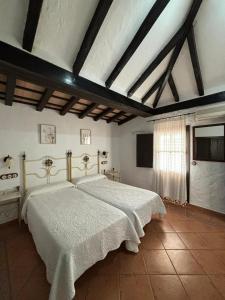 a bedroom with a large bed and a window at Cortijo Huerta Dorotea in Prado del Rey +28 photos