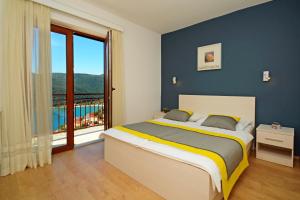 Un pat sau paturi într-o cameră la Three-Bedroom Apartment Rabac near Sea