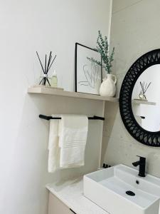 a white bathroom with a sink and a mirror at 15 On Candy in Midrand