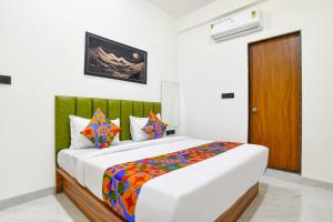 a bedroom with a large bed with a colorful blanket at FabHotel The Backyard Bowl in Indore