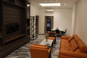 a living room with couches and a tv and a table at two seasons hotel in Bangui
