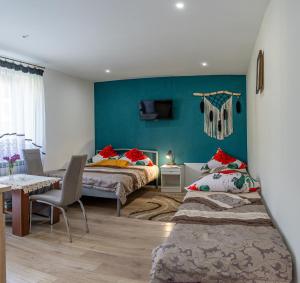 a bedroom with two beds and a table and chairs at Agroturystyka Pod Lasem na Roztoczu in Sochy +60 photos