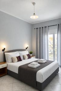 a bedroom with a large bed and a window at DOMES APARTMENTS in Kallithea Halkidikis
