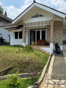 a house with a motorcycle parked in front of it at Lamar Villas 2 in Tengahgirang