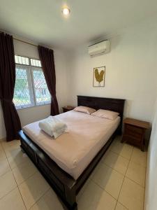 a bedroom with a large bed and two windows at Lamar Villas 2 in Tengahgirang