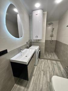 a bathroom with a sink and a washing machine at Solis apart otel in Batumi +16 photos