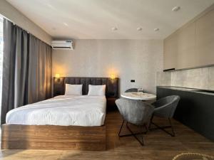 a bedroom with a bed and a table and a chair at Solis apart otel in Batumi