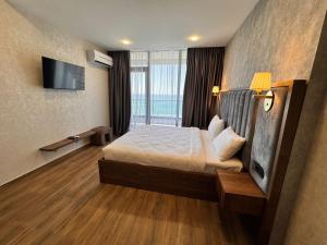 a hotel room with a bed and a flat screen tv at Solis apart otel in Batumi