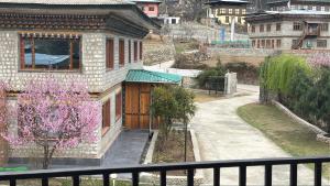 a view from a balcony of a building with purple flowers at Taktshang Paradise in Paro