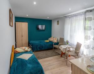 a living room with a bed and a dining room at Agroturystyka Pod Lasem na Roztoczu in Sochy