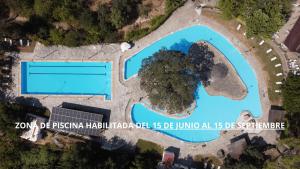 an aerial view of a swimming pool with a tree at Edomus Castillo de las Guardas in Seville