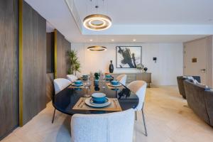 a dining room with a black table and white chairs at Vacationer Holiday Homes I Luxurious 3 Bedroom I Iconic FIVE Palm in Dubai +56 photos