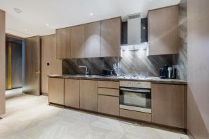 a kitchen with wooden cabinets and a sink at Vacationer Holiday Homes I Luxurious 3 Bedroom I Iconic FIVE Palm in Dubai