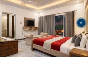 a bedroom with a large bed and a living room at Hotel Red Roof & Restaurant in Abbottabad