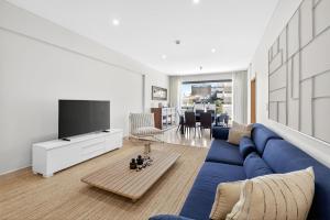 a living room with a blue couch and a tv at Aquamar Pro 116 in Quarteira